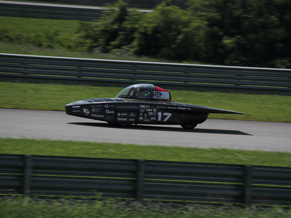 Solar-powered race car with number 17 on a track.